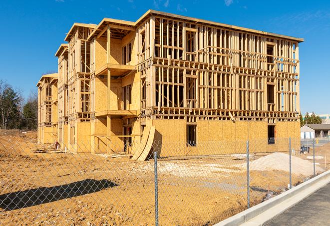 workers protected by temporary barrier fence during building maintenance in Seagoville